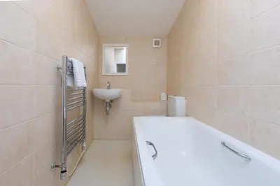 a bathroom with a white tub and a sink at 85 Back Road East in St Ives