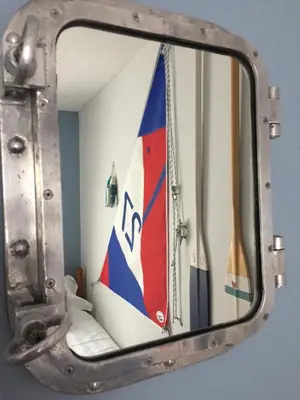 a mirror with a reflection of a sailboat at QUILLET COTTAGE, 2 GLENTOWAN ROAD in St Austell