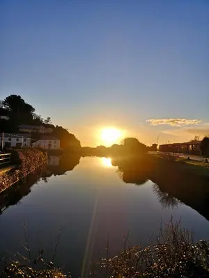 a river with the sun setting in the background at QUILLET COTTAGE, 2 GLENTOWAN ROAD in St Austell