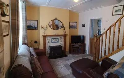 a living room with a couch and a fireplace at QUILLET COTTAGE, 2 GLENTOWAN ROAD in St Austell