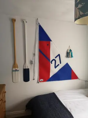 a room with a bed with a flag on the wall at QUILLET COTTAGE, 2 GLENTOWAN ROAD in St Austell