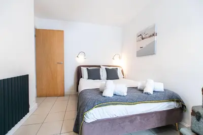 a bedroom with a large bed with two pillows at Mariner's Belle in St Ives