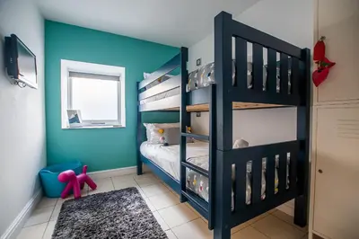 a bedroom with blue walls and a bunk bed at Mariner's Belle in St Ives