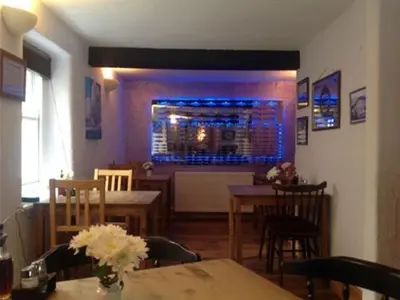 a dining room with a table and a bar at The Safe Harbour Hotel in Fowey