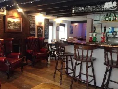 a bar with chairs and a counter in a pub at The Safe Harbour Hotel in Fowey