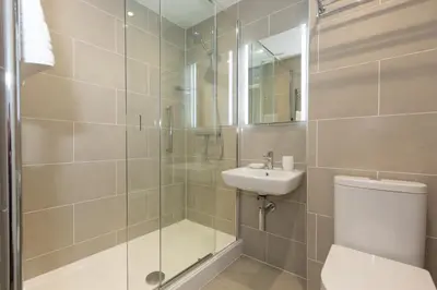 a bathroom with a shower and a toilet and a sink at 35 Carrack Widden in St Ives