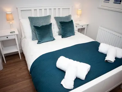 a bedroom with a large bed with blue and white pillows at 3 Sunday School Court in St Ives