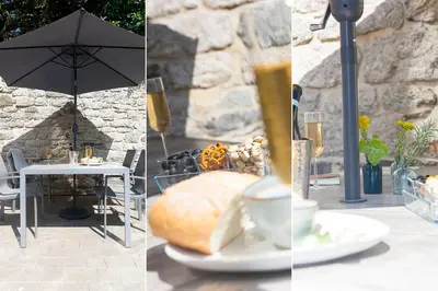 a table with an umbrella and a table with a plate of food at 3 Sunday School Court in St Ives