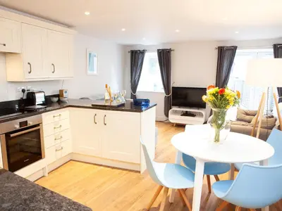 a kitchen and living room with a table and chairs at 3 Sunday School Court in St Ives