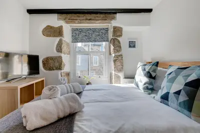 a bedroom with a large bed and a window at Maranatha in St Ives