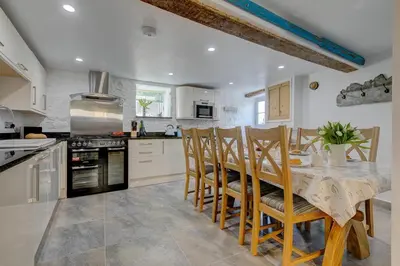 a kitchen with a table and chairs and a kitchen with a stove at Maranatha in St Ives