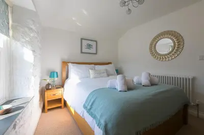 a bedroom with a bed and a mirror on the wall at Maranatha in St Ives