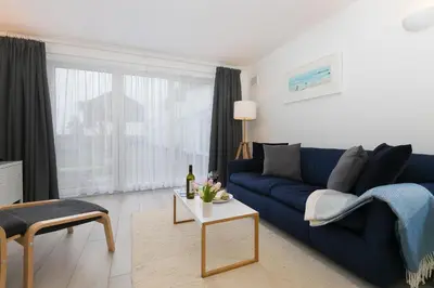 a living room with a blue couch and a table at 21 Carthew Court in St Ives