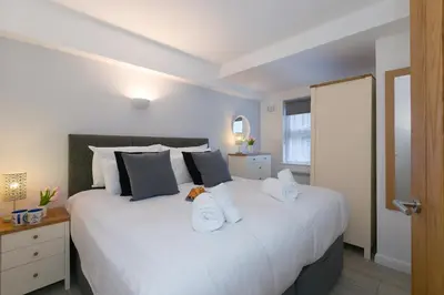 a bedroom with a large white bed with towels on it at 21 Carthew Court in St Ives