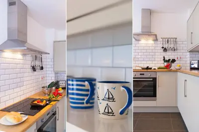 a white kitchen with a blue and white vase on the counter at 21 Carthew Court in St Ives
