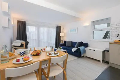 a kitchen and living room with a table and chairs at 21 Carthew Court in St Ives