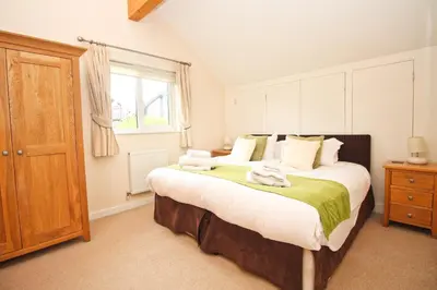 a bedroom with a large bed with towels on it at ON-SITE WATERSPORTS family lodge in Saint Columb Major