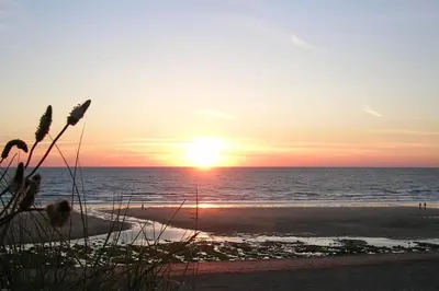 a sunset on the beach with the sun setting at Harrington Flats in Newquay