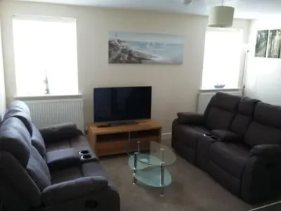 a living room with two couches and a television at Harrington Flats in Newquay