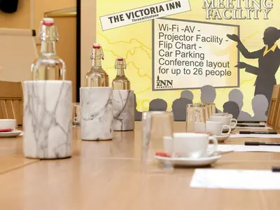 a table with bottles and cups on it with a sign at The Victoria Inn in Truro