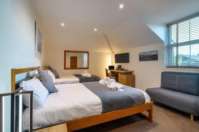 a bedroom with two beds and a couch at The Victoria Inn in Truro