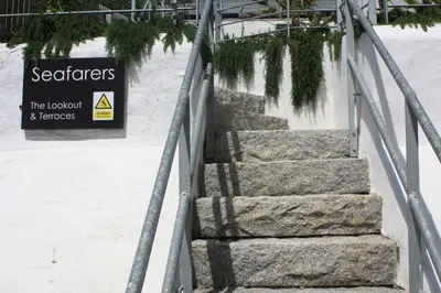 a set of stairs with a sign in the snow at Seafarers, Mevagissey - Coastguard Cottage overlooking harbour in Mevagissey