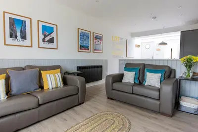 a living room with two couches and a rug at Seafarers, Mevagissey - Coastguard Cottage overlooking harbour in Mevagissey