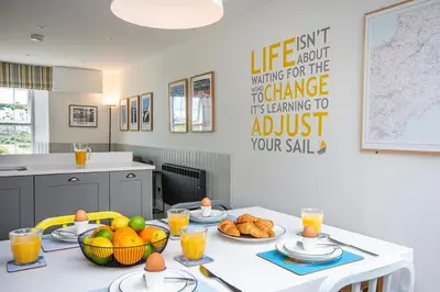 a kitchen with a table with food on it at Seafarers, Mevagissey - Coastguard Cottage overlooking harbour in Mevagissey