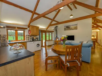 a kitchen and living room with a wooden ceiling at Hook Cottage in Looe
