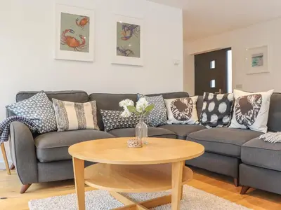 a living room with a couch and a table at Garden House in Gorran Haven
