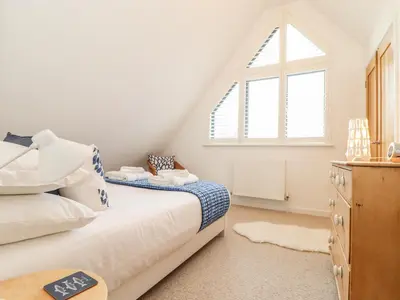 a bedroom with a bed and a window at Garden House in Gorran Haven
