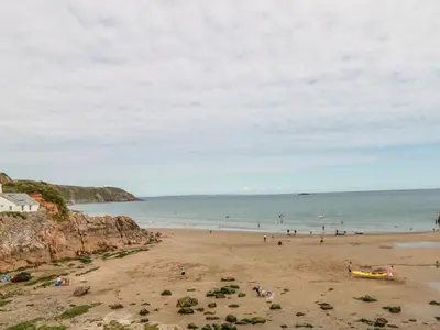 a group of people on a beach near the ocean at Garden House in Gorran Haven