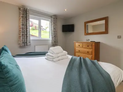 a bedroom with a bed with towels on it at Lodge Sixty Six in Saint Columb Major