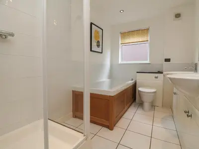 a bathroom with a tub and a toilet and a sink at Lodge Sixty Six in Saint Columb Major