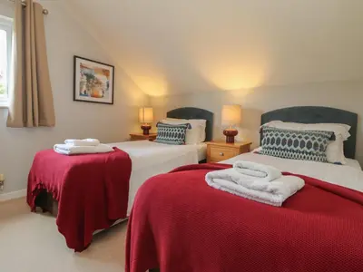 two beds in a room with red and white sheets at Lodge Sixty Six in Saint Columb Major