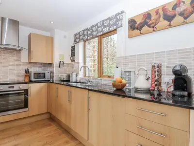 a kitchen with wooden cabinets and a counter top at Whitsand in Saltash