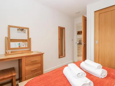 a bedroom with two towels on a bed with a mirror at Whitsand in Saltash