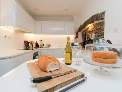 a table with a loaf of bread and a bottle of wine at Rock House in Tintagel