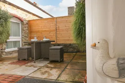 a white duck standing next to a patio at Rock House in Tintagel