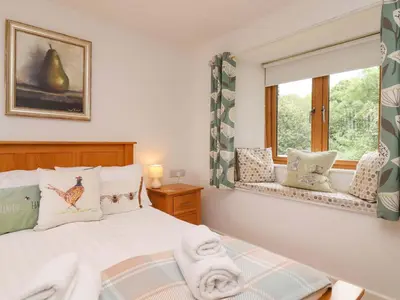 a bedroom with a bed and a window at Cawsand in Saltash
