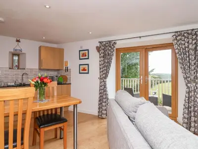 a kitchen and living room with a couch and a table at Cawsand in Saltash