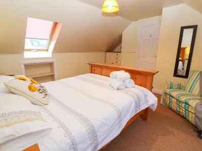 a bedroom with a bed with a teddy bear on it at Tynk in St Merryn