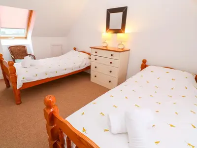 a bedroom with two twin beds and a dresser at Tynk in St Merryn