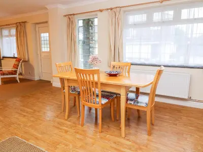 a dining room with a wooden table and chairs at Tynk in St Merryn