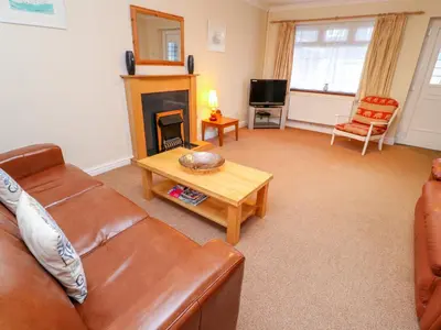 a living room with a couch and a fireplace at Tynk in St Merryn