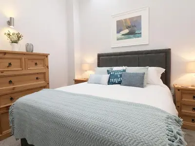 a bedroom with a large bed with blue pillows at Hazel Barn in Falmouth