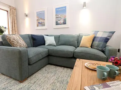 a living room with a couch and a table at Hazel Barn in Falmouth