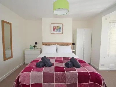 a bedroom with a large bed with a purple blanket at Seagrass in Newquay