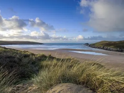 a sandy beach with the ocean in the background at Seagrass in Newquay