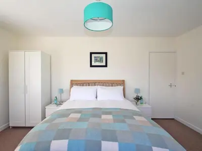 a bedroom with a large bed with a blue at Seagrass in Newquay